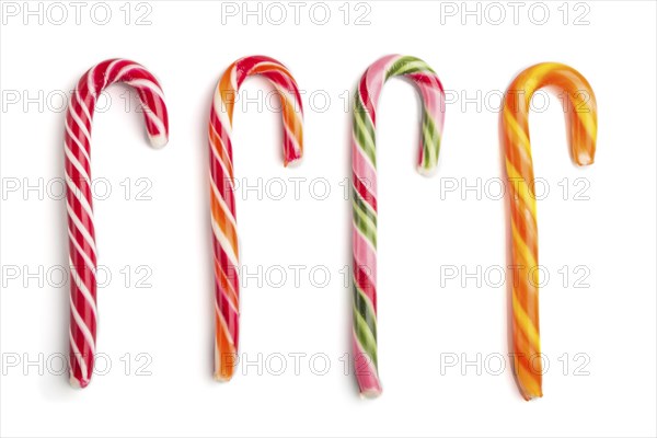 Four christmas cane candies isolated on white background. close up, top view, flat lay
