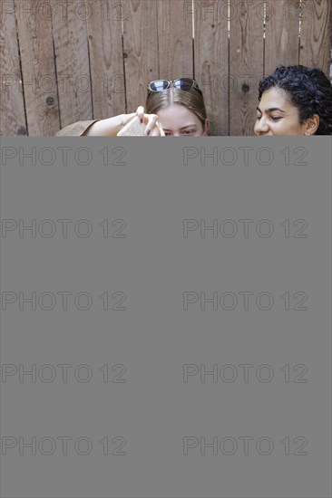 Young woman giving a lamb a bottle of milk in her arms, North Sea island of Borkum, 18.05.2024.
