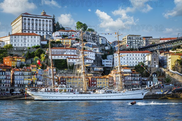 View of Porto city and Douro river with sailing ship from famous tourist viewpoint Marginal de Gaia