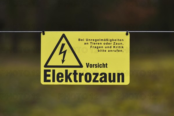 Leimen, Germany, April 2020: Yellow electric fence warning sign with German text saying 'Attention,