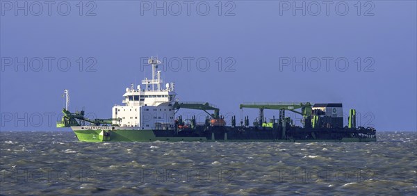 DEME trailing suction hopper dredger Uilenspiegel at sea, used for sand replenishment, beach