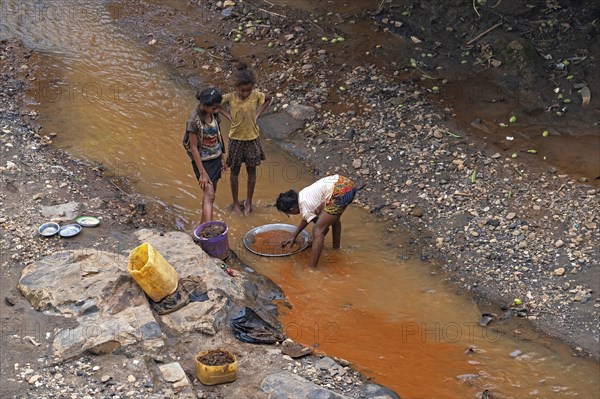 Young girls panning for gold in stream at Dabolava, gold miners' village near Miandrivazo, Menabe