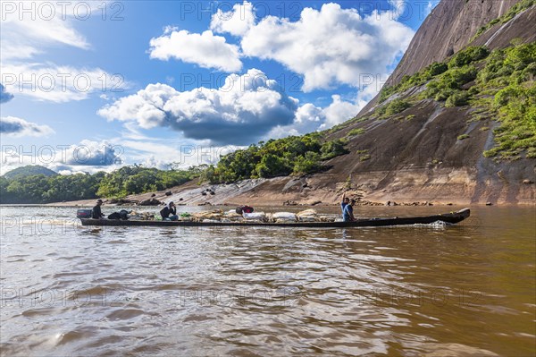 Fisherman with their fish before the huge granite hills, Cerros de Mavecure, Eastern Colombia