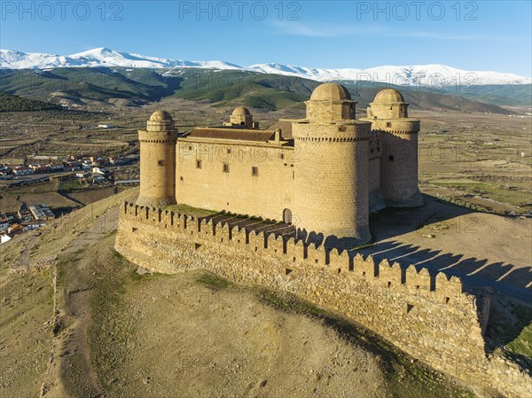 The Renaissance castle of La Calahorra against the snow-capped Sierra Nevada mountain range, aerial