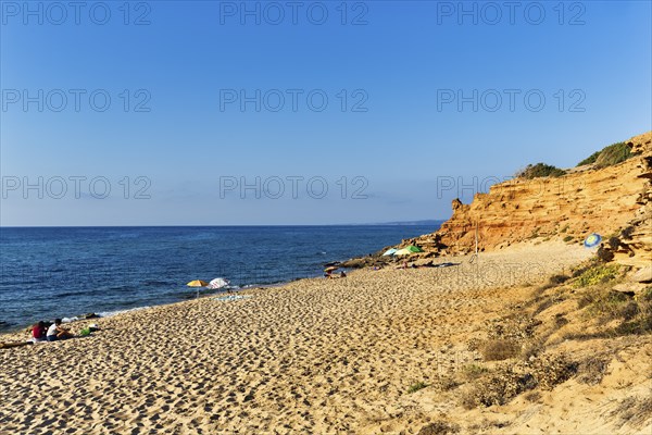 Tourists on the sandy beach, red rocks, holiday by the sea, Spiaggia di Scivu, Arbus, Costa Verde,