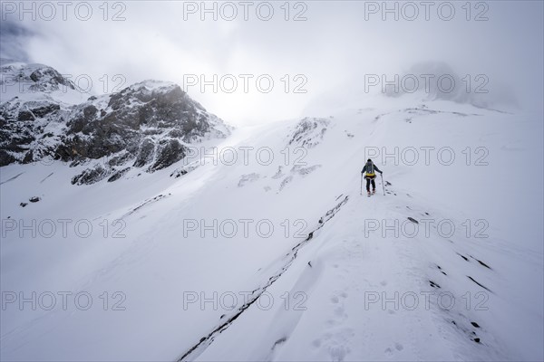 Ski tourers in a snowy mountain landscape, ascent to the Wildhorn, cloudy mood, high tour, Bernese