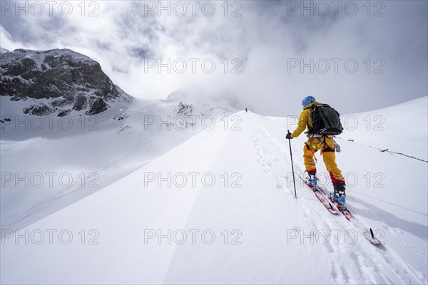 Ski tourers in a snowy mountain landscape, ascent to the Wildhorn, cloudy mood, high tour, Bernese