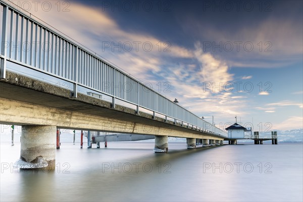 A long jetty over a calm lake with a slightly cloudy sky and daylight, harbour, Immenstaad, Lake