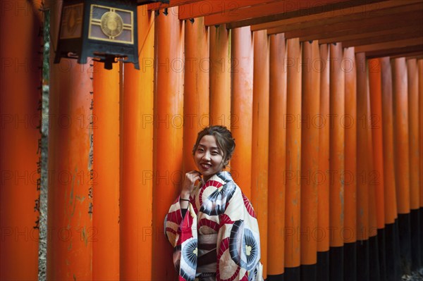 24.12.2017, Kyoto, Japan, Asia, A young Japanese woman stands in one of the torii pathways leading