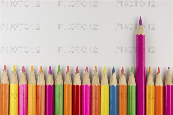 Abstract composition of a set wooden colour pencils against a white background