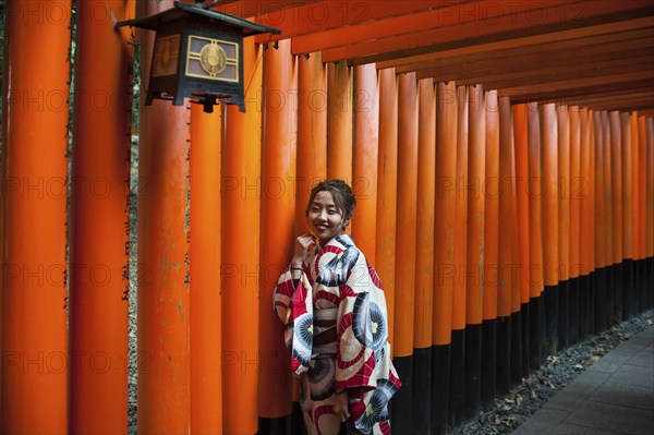 24.12.2017, Kyoto, Japan, Asia, A young Japanese woman stands in one of the torii pathways leading