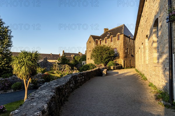 Picturesque narrow street of the medieval village of Locronan a sunny day of summer at evening