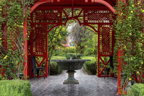 Marrakesh, Morocco, 24 March, 2024: fountain and red gazebo in the heart of the Anima Garden in