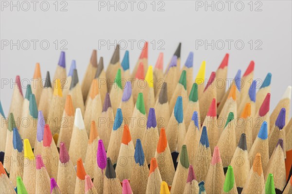 Abstract composition of a set wooden colour pencils against a white background