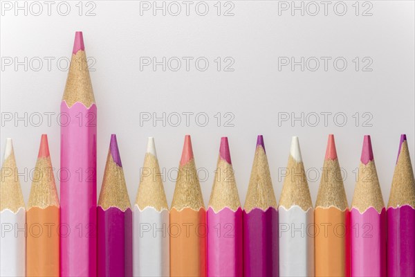 Abstract composition of a set wooden colour pencils against a white background