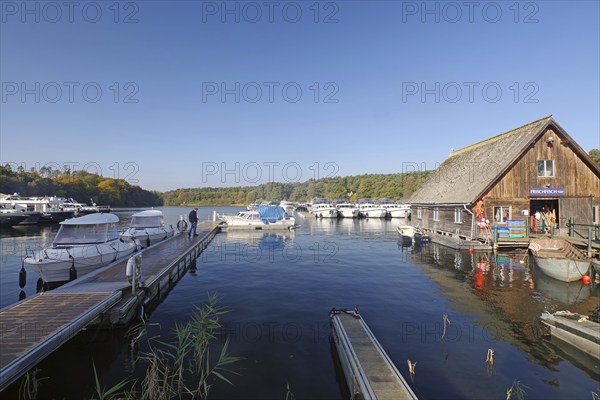 Spacious harbour with boats and jetty, wooden hut on the shore, blue water, fish shop, Eldenburg,