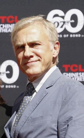 Christoph Waltz supports producers Michael G. Wilson and Barbara Broccoli at their handprints