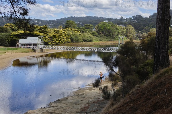 An angler at a lovely spot by the Erskine River near the Swing Bridge, Lorne, Victoria, Australia,