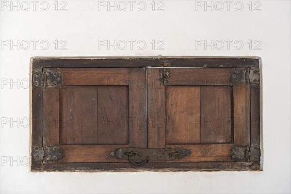 An old wooden shutter in a white wall, Mexico, Central America
