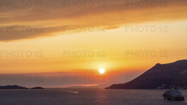 Cloudy atmosphere at sunset by the sea, view from the bell tower, cruise ship near Korcula, Korcula