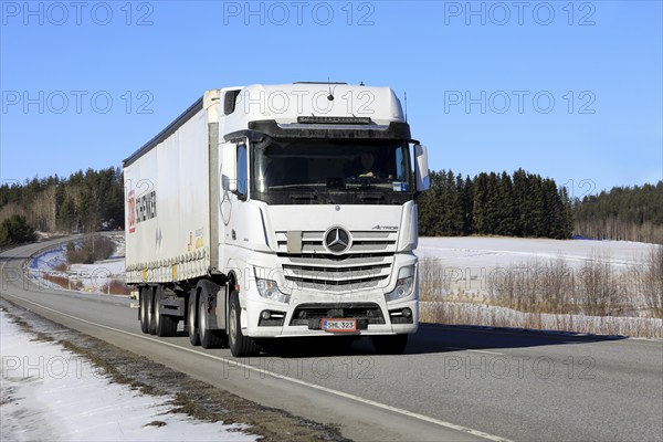 White Mercedes-Benz Actros 2653 truck pulls DB Schenker semi trailer along highway on a sunny day