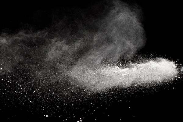 Bizarre forms of white powder explosion cloud against black background.White dust particles splash