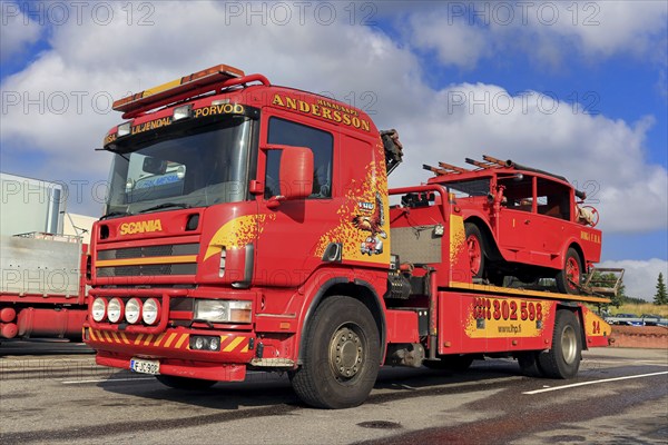 Scania flatbed tow truck of Hinaus Andersson Oy carrying a vintage fire truck. Salo, Finland.