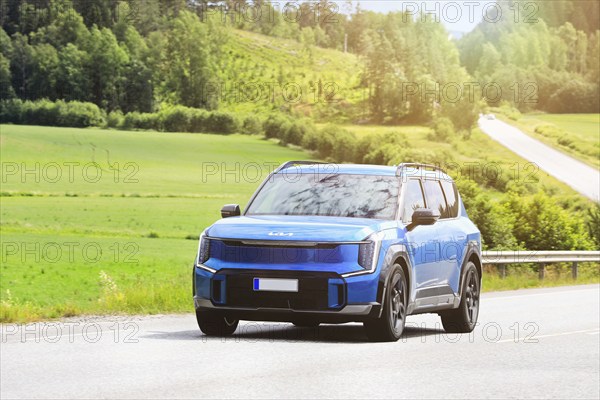 2024 blue Kia EV9 SUV car on road. Kia EV9 wins Red Dot Award: Product Design 2024 'Best of the