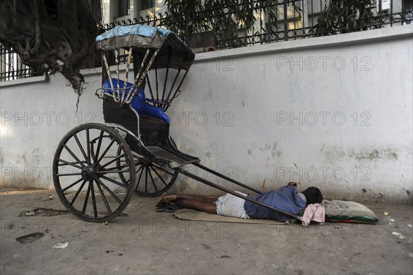 25.02.2011, Kolkata, West Bengal, India, Asia, A rickshaw driver sleeps next to his wooden rickshaw