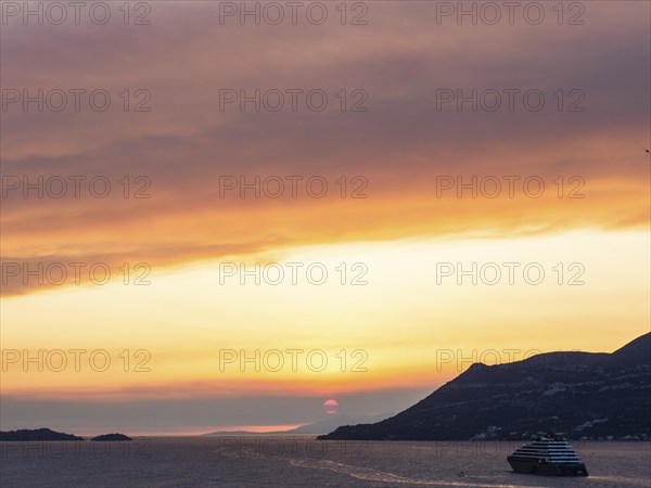 Cloudy atmosphere at sunset by the sea, view from the bell tower, cruise ship near Korcula, Korcula
