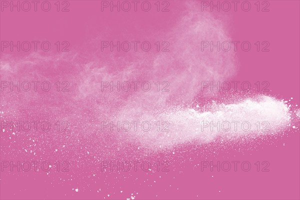 White powder explosion on pink background