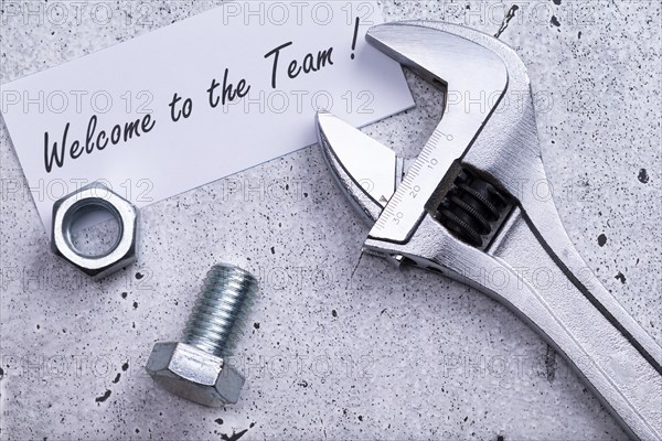 The photo shows a label with the inscription 'welcome to our team' with a spanner and screw on a