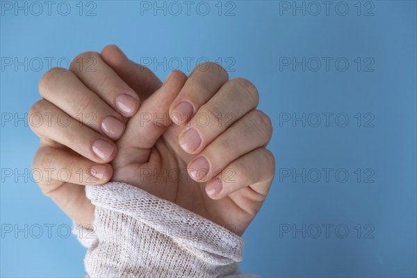 Pastel softness manicured nails on blue background. Woman showing her new manicure in colors of