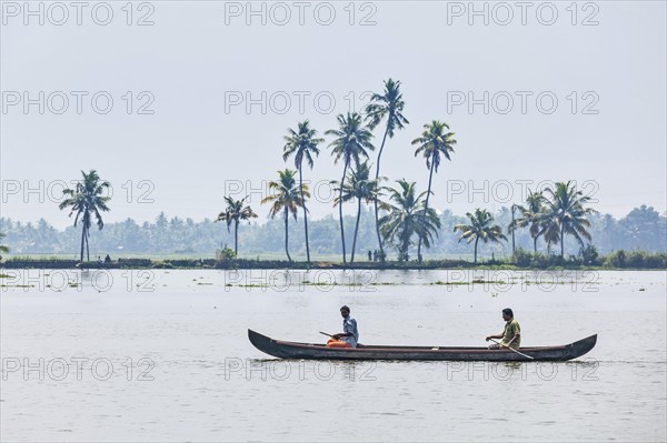 KERALA, INDIA, MAY 5, 2010: Unidentified indian men in small boat in backwaters. Kerala backwaters