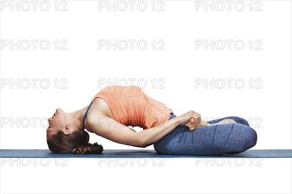 Beautiful sporty fit yogini woman practices yoga asana Matsyasana, fish pose in studio isolated on