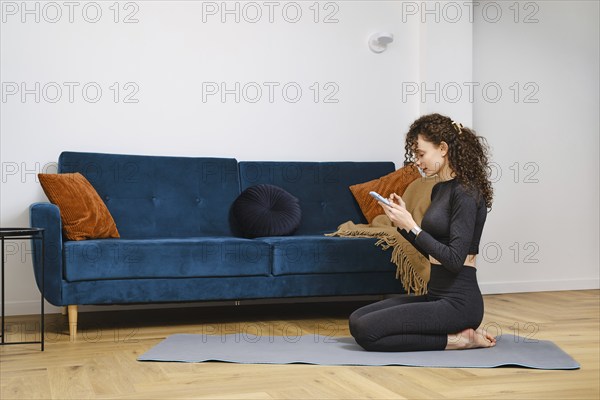Young woman wants to work out fitness at home and is looking for saved links to videos in bookmarks