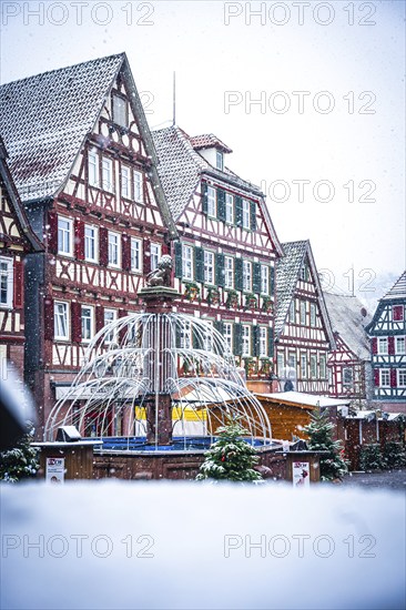 Half-timbered house backdrop on a snow-covered Christmas market with winter decorations, Black