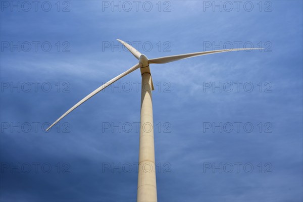Green renewable alternative energy concept, wind generator turbine generating electricity in blue