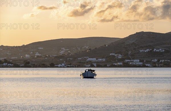 Fishing boat on the sea, behind hill of Paros island, Naoussa, Paros, Cyclades, Greece, Europe