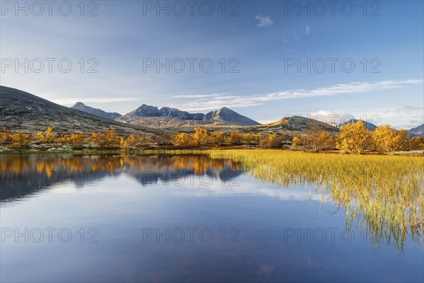 Reflection of the autumn landscape in Rondane National Park, mountains Høgronden, Midtronden and