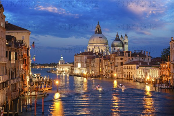 View of Venice Grand Canal with boats and Santa Maria della Salute church in the evening from Ponte