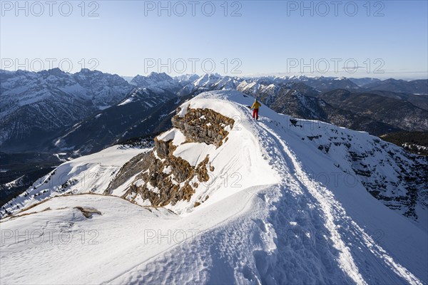 Ski tourers at the summit of Schafreuter, view of snow-covered mountain panorama, Karwendel, Tyrol,
