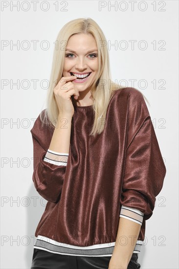 Beautiful happy blonde woman smiling with expression thinking about pleasant things