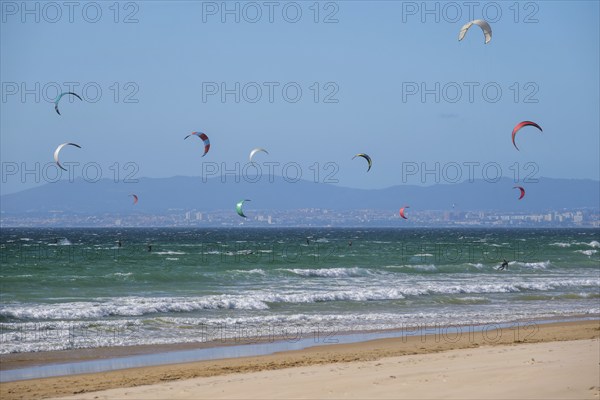 Kiteboarding kitesurfing kiteboarder kitesurfer kites on the Atlantic ocean beach at Fonte da Telha