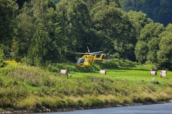 An ADAC rescue helicopter attempts to land on the banks of the Elbe in Schöna in Saxon Switzerland