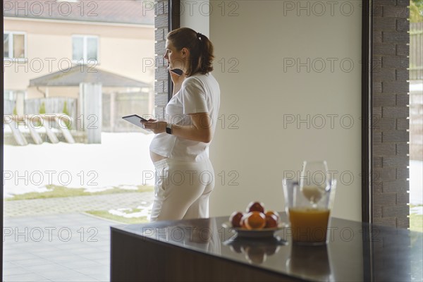 Attractive pregnant woman calls a doctor for an online consultation or to find out the results of