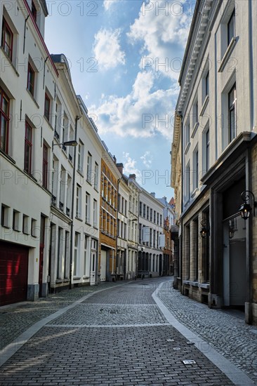 Antwerp cobblestone street with alley row of medieval houses at the old European city port, Belgium