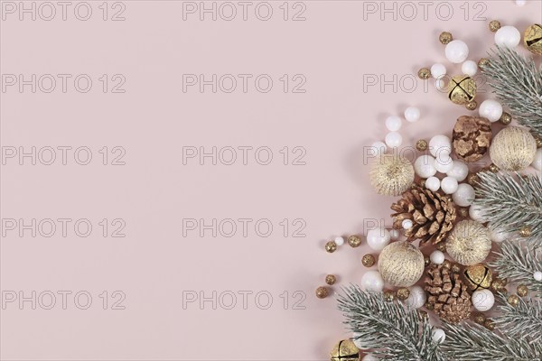 Christmas banner with for branches, cones, golden tree baubles and snowballs on side of pink