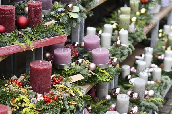 Traditional advent wreaths with single big dark red, pink and white candles and seasonal Christmas