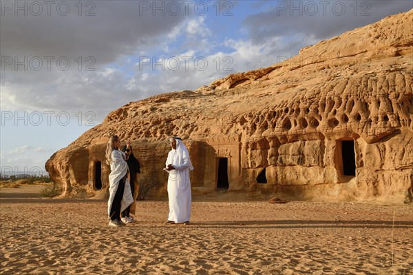 Tourists in front of the Nabataean tombs at the rock Qasr Al-Bint, Hegra or Mada'in Salih, AlUla